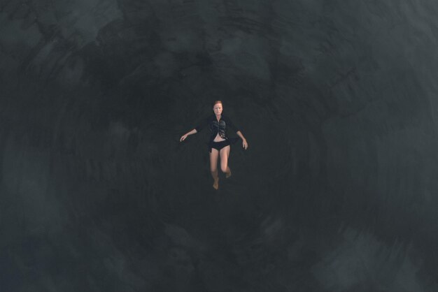 어두운 깊은 물 표면에서 편안한 소녀