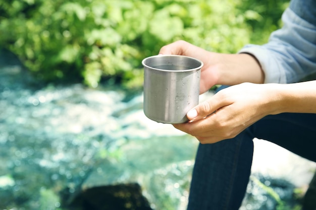 Girl relaxing with drink in forest