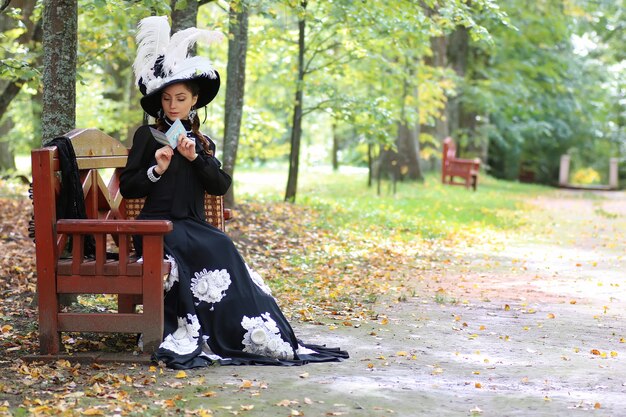 Girl in retro dress past century read letter on the bench