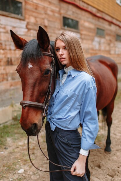 Girl rider standing next to the horse