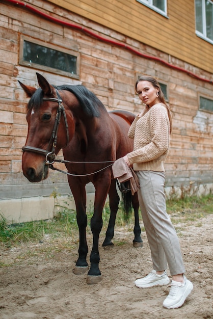 Girl rider standing next to the horse