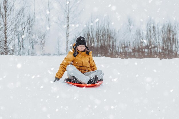 A girl rides down a slide in a winter park a healthy lifestyle a sports walk