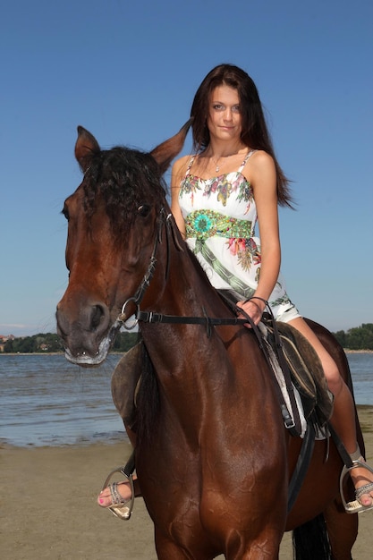 Девушка верхом на лошади на фоне моря