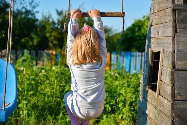 Girl riding a swing in the village