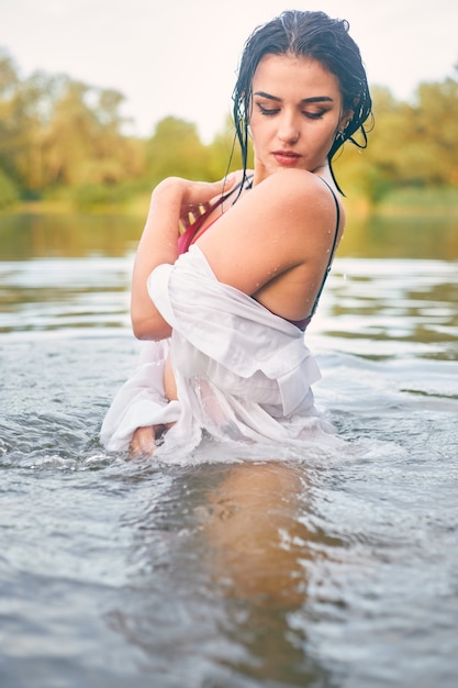 Girl in the river in a white shirt , one