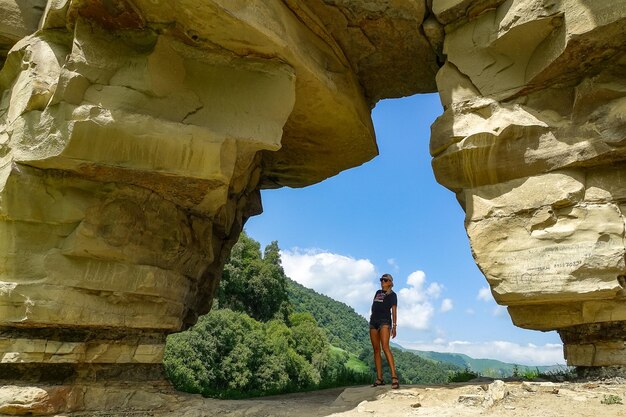 A girl in a rock arch on the Aktoprak pass in the Caucasus Russia June 2021