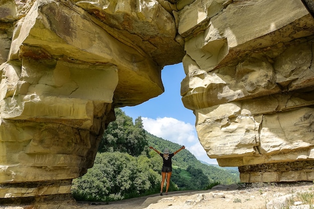 A girl in a rock arch on the Aktoprak pass in the Caucasus Russia June 2021