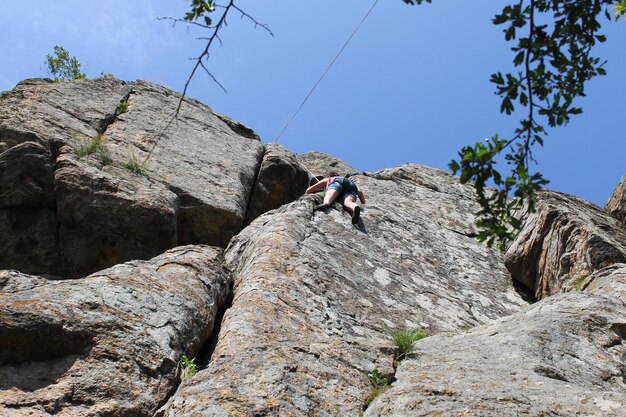 Girl rock climber climbs on a rock