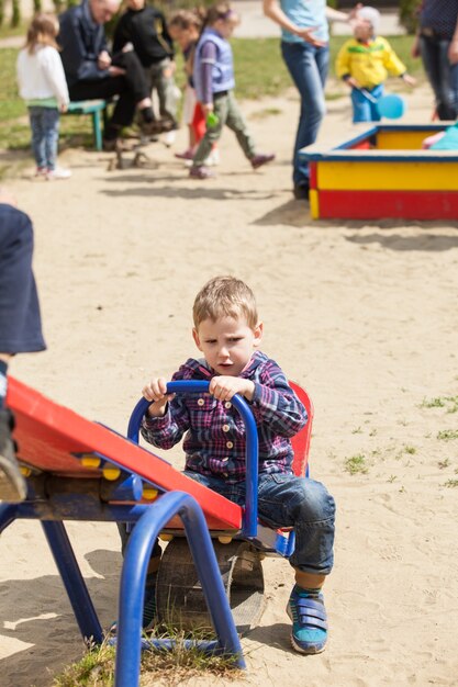 Girl rocks on a seesaw at the playground