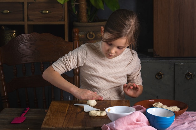 Girl rolls the dough