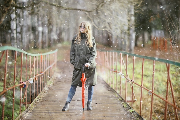 girl romantic portrait first snow autumn, snowflakes blurred background seasonal winter