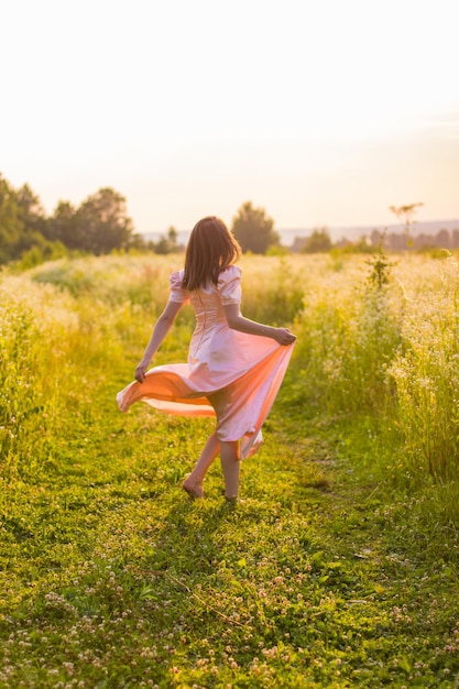Girl running across the field in a pink dress