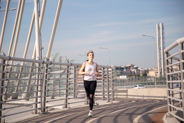 La ragazza attraversa il ponte all'alba