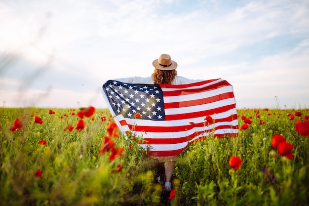 A girl runs across a poppy field