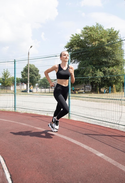 The girl runs around the sports stadium Running sports