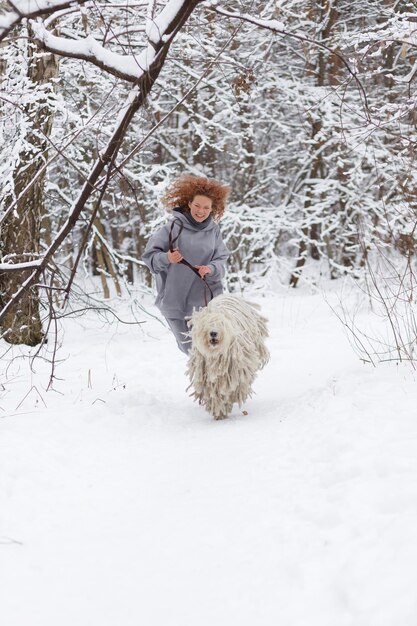 a girl runs in the woods with a big dog