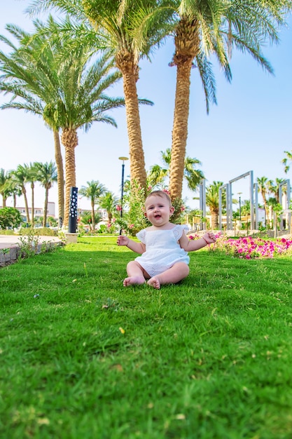 The girl's children are sitting under a palm tree