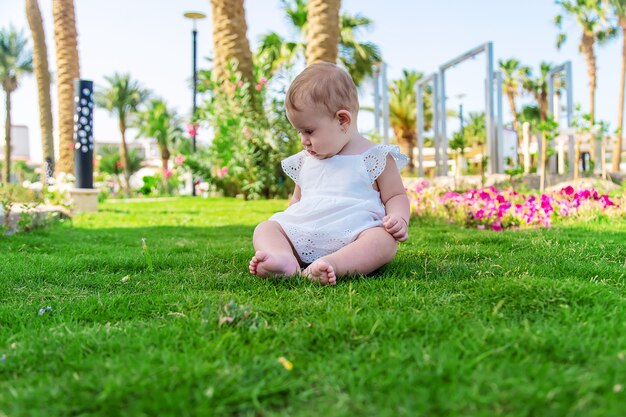 The girl's children are sitting under a palm tree