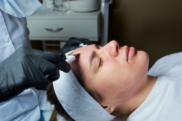 Girl's face after a warming lotion during an ultrasonic procedure in the cosmetology office