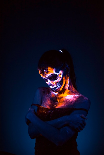 Girl's face painted UV skull