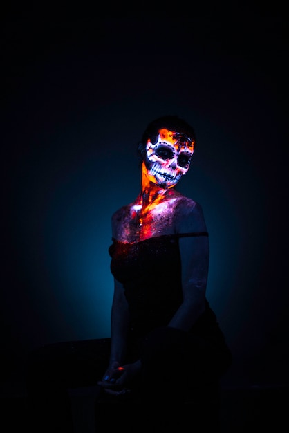 Girl's face painted uv skull