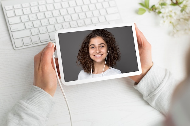 Il viso della ragazza sullo schermo del tablet. conferenza in linea. seminario web.