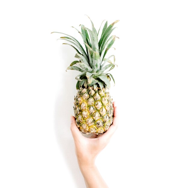 Girl's hand holding pineapple.