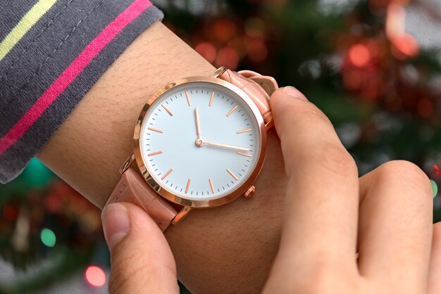 Photo girl's hand with wrist watch in front of a laptop computer