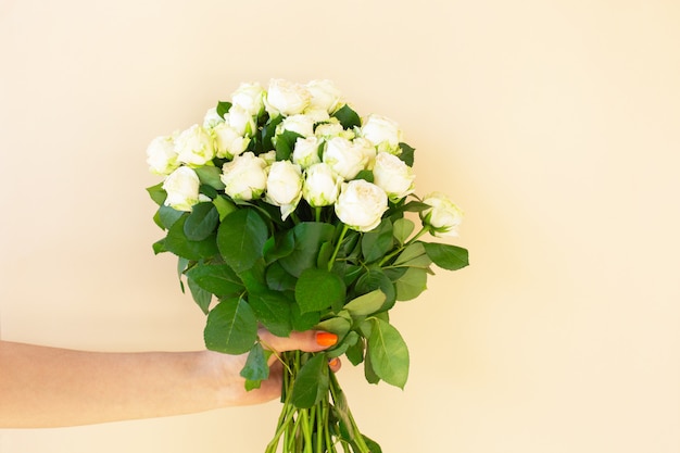 Girl's handen met Mooi boeket van witte rozen op lichte achtergrond