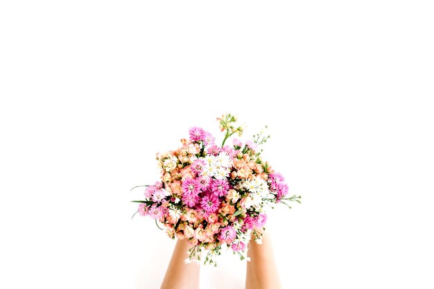 Girl's handen met wilde bloemen boeket op wit