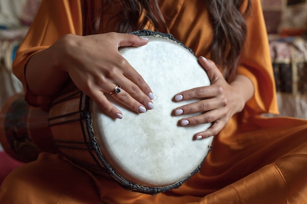 The girl's hands play a beautiful melody on an African drum. meditation.