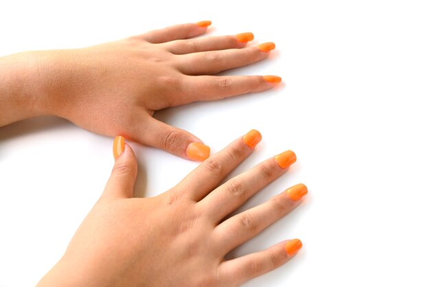 Foto le mani della ragazza con il manicure della donna delle unghie finte arancioni