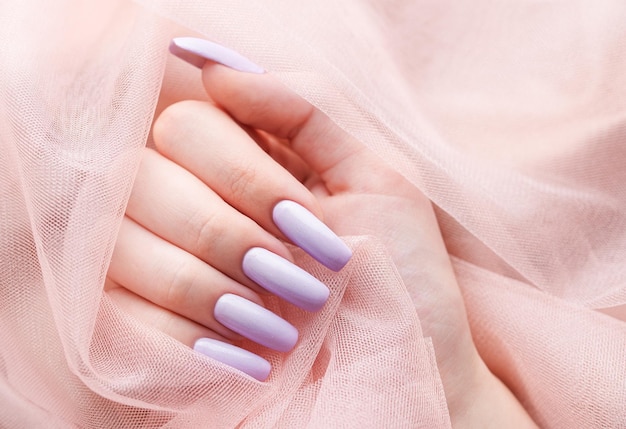 Girl's hands with a soft purple manicure