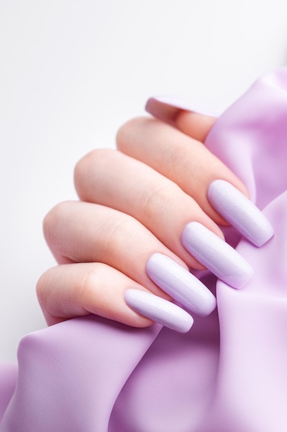 Girl's hands with a soft purple manicure