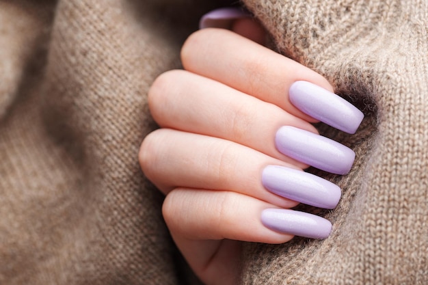 Girl's hands with a soft purple manicure