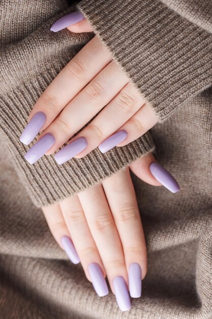 Girl's hands with a soft purple manicure