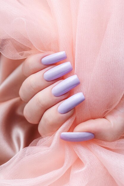 Girl's hands with a soft purple manicure