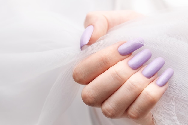 Girl's hands with a soft purple manicure