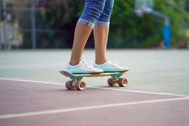 Le gambe della ragazza su uno skateboard