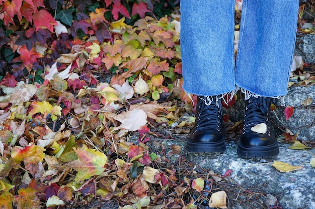 Girl\'s legs on the stairs in the autumn park in black boots\
with space for text autumn concept