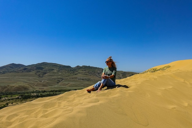 A girl on the sand dunes of Sarykum The desert in Dagestan Russia 2021