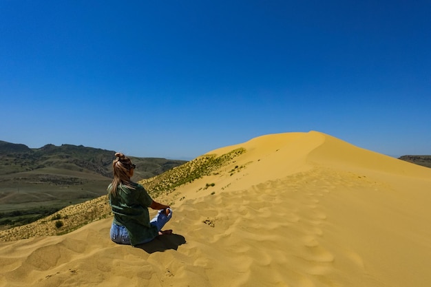 A girl on the sand dunes of Sarykum The desert in Dagestan Russia 2021