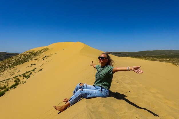 A girl on the sand dunes of Sarykum The desert in Dagestan Russia