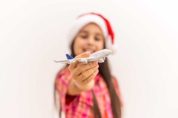 Girl in Santa hat holding model airplane