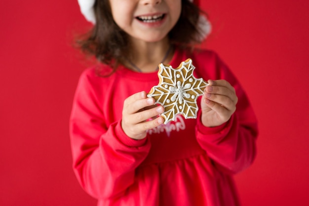 Girl in santa hat with christmas gingerbread - snowflake