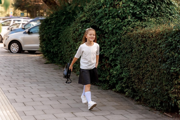 a girl in a school uniform walks in the park