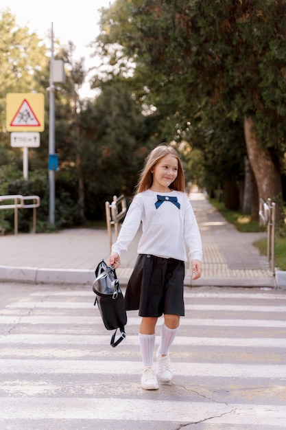 a girl in a school uniform walks in the park