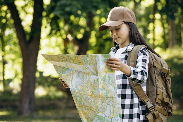 Girl scout walking in woods with map