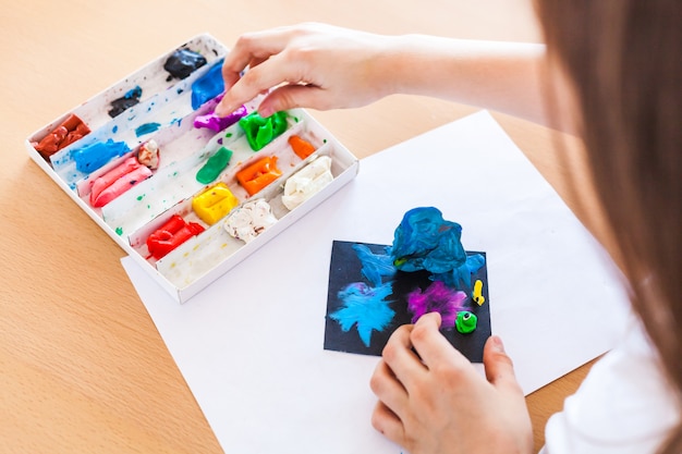 La ragazza scolpisce da plastilina, argilla, pasta, fai-da-te a casa, creatività durante le vacanze