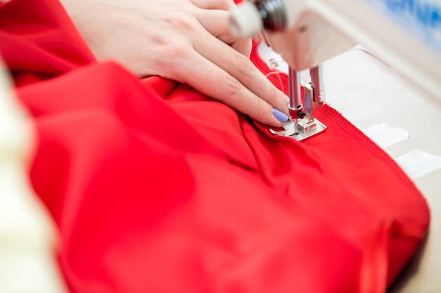 Girl seamstress sew on the sewing machine